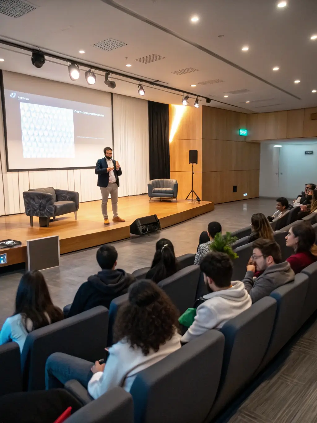 A photo of a lecture hall with a speaker presenting on the history of the Paris Commune, with attendees listening and taking notes.